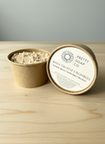 kraft paper cup of bath truffle crumbles with 'Pretty Soap Co' label on a wooden surface