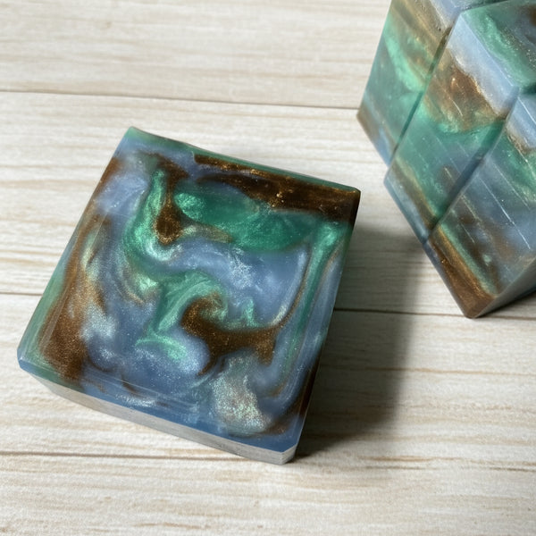 A green and brown soap bar on a wooden surface
