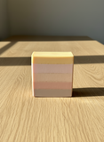 Layered soap bar on a wooden surface
