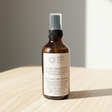 Bottle of 'Cozy Sweater' room spray from Pretty Soap Co on a wooden surface with a neutral background