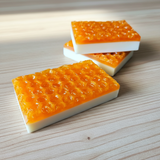 3 bars of soap with honeycomb design on top on a wooden table