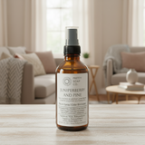 Bottle of Juniperberry and Pine room spray from Pretty Soap Co. on a wooden surface