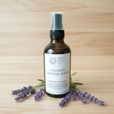 lavender hydrosol in an amber spray bottle with lavender flower sprigs on a wooden table