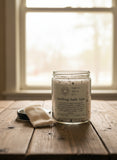 Jar of bath salts with a label on a wooden surface accompanied by a reusable tea bag.