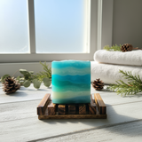 Blue soap bar sitting on a wooden tray in a dark wood background