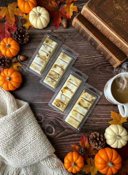Packaged treats on a wooden surface with pumpkins, leaves, and books