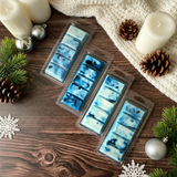 Four plastic molds with blue and white wax bars on a wooden surface