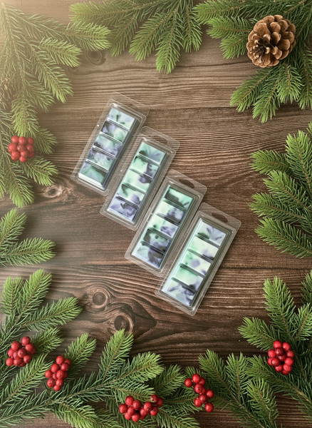 Packaged candles on a wooden surface with Christmas decorations