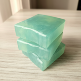 stack of 3 blue soap bars on a wooden surface